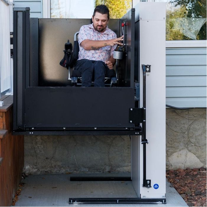 Man using wheelchair lift to exit home